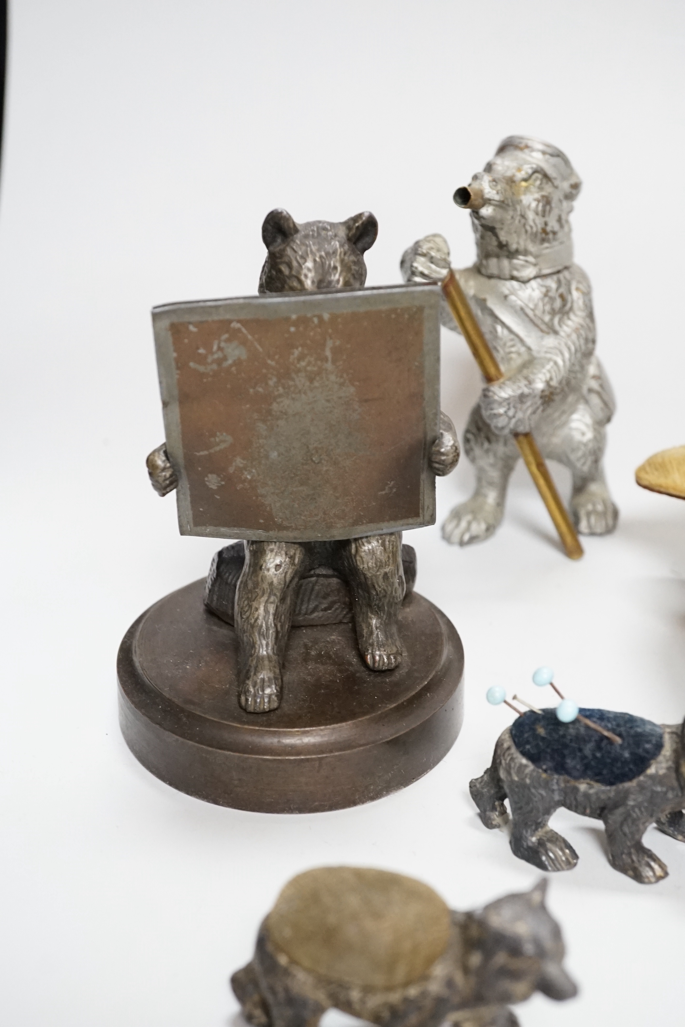 Four metal bear pin cushions, a money box, a bear stud box, three metal bears, a mother of pearl metal bear dish and an advertising bear on a box